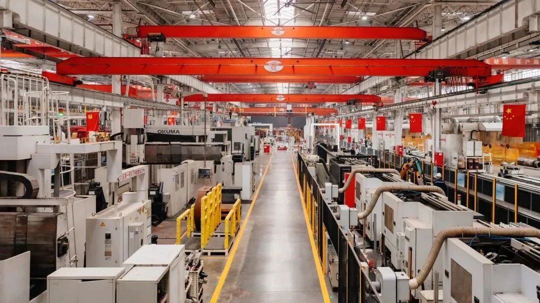 Company manufacturing workshop with machining equipment, overhead cranes, and organized production lanes