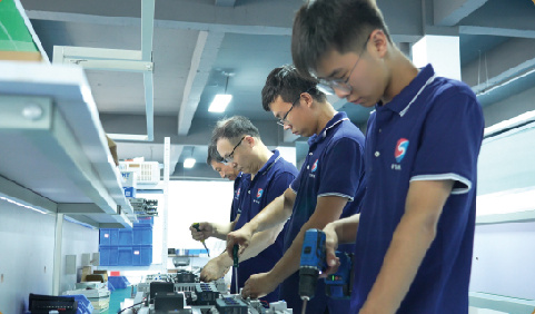 Factory engineers assembling equipment at production workstations